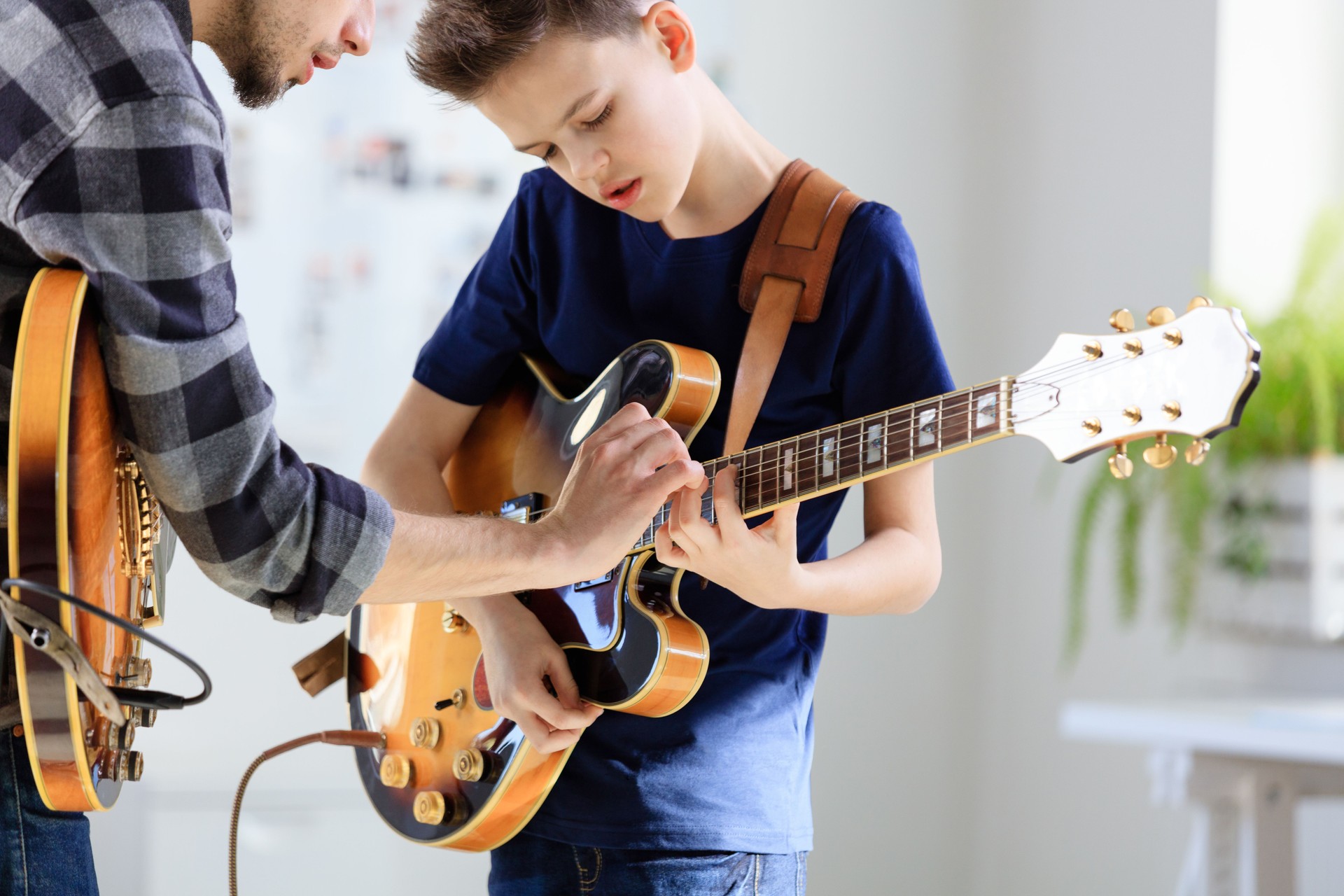 Teenage boy learning electric guitar from trainer